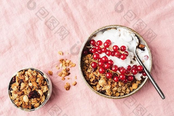 自制的格兰诺拉麦片希腊酸奶红色的醋栗浆果粉红色的背景前视图健康的早餐食物复制空间