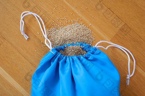 白色藜麦种子透明的蓝色的可重用的袋木背景素食者食物概念