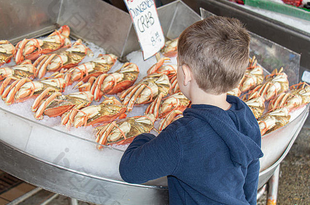 年轻的男孩邓杰内斯蟹出售鱼市场西雅图华盛顿