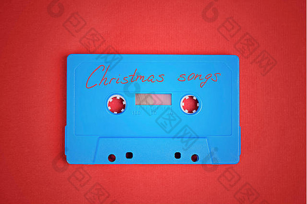 蓝色的音频盒式磁带磁带圣诞节歌曲铺设红色的纸背景