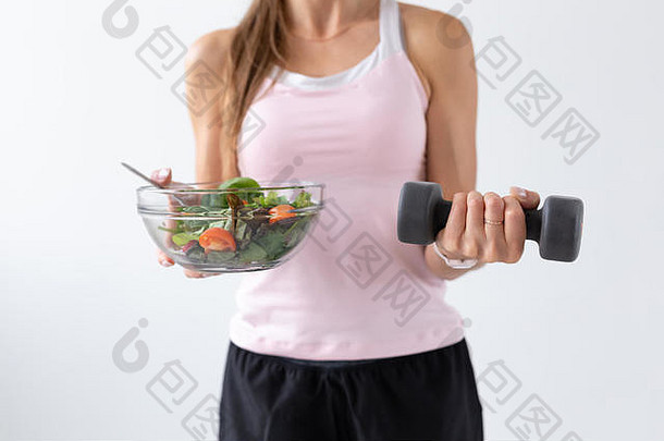 饮食食物健身概念关闭健康的沙拉哑铃女手白色背景