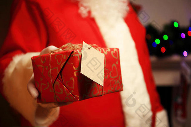 圣诞老人老人戴着手套手持有礼品盒
