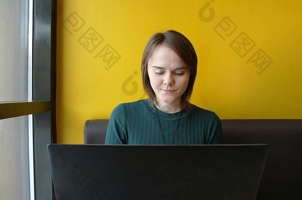 美丽的年轻的女孩坐着咖啡馆表格移动PC作品电脑类型键盘屏幕情感表达式