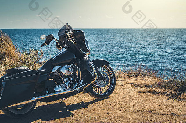 黑色的摩托车美丽的海岸蓝色的天空起草原夏天