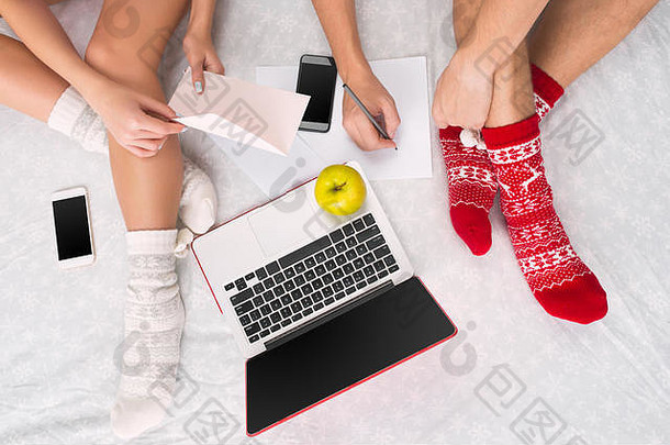 高加索人夫妇首页互联网技术移动PC电话人坐着地板上彩色袜子圣诞节爱生活方式概念