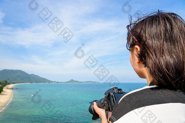 十几岁的女孩持有数码单反相机相机高美丽的自然景观蓝色的海Lamai海滩高的观点夏天旅行