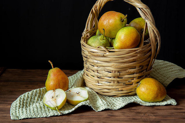 柳条篮子成熟的梨站木表格附近的梨梨减少一半篮子绿色毛巾