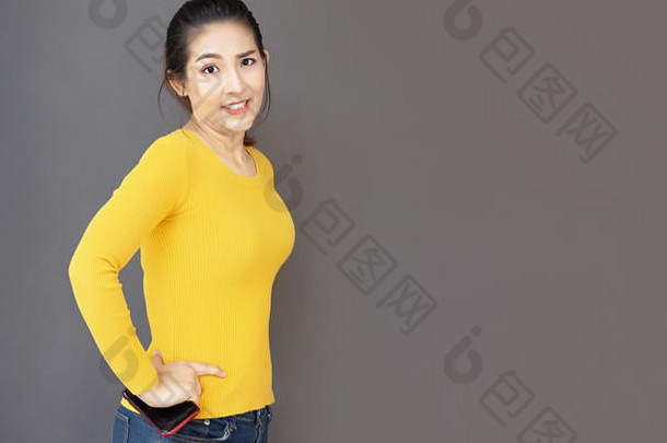 肖像亚洲女人可爱的行动休闲黄色的衬衫牛仔裤移动孤立的空间