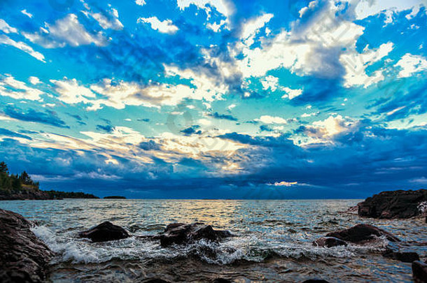 才华横溢的五彩纸屑云湖岸色彩斑斓的云填满蓝色的天空岩石湖优越的海岸线海景背景复制空间