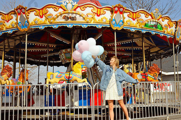 美丽的年轻的女人色彩斑斓的气球娱乐公园