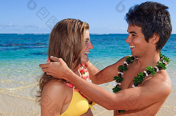 年轻的岛男人。花法律年轻的女人海滩夏威夷