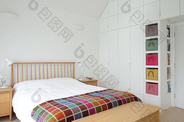 斯堪的那维亚启发卧室室内显示木卧室家具白色画墙白色床上用品色彩鲜艳的毯子