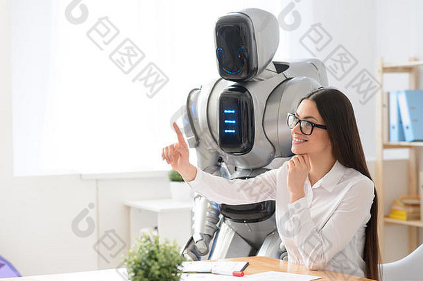 愉快的女孩坐着办公室机器人