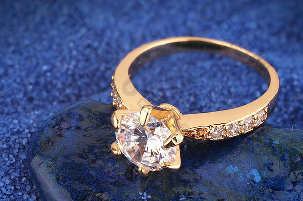 金Jewelery环钻石蓝色的背景
