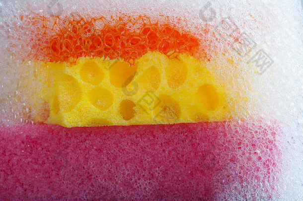 清洁海绵肥皂泡沫前色彩斑斓的紫罗兰色的橙色黄色的宏视图泡沫肥皂水灰色的黑色的背景
