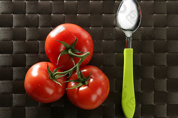 红色的西红柿分支充满活力的绿色勺子