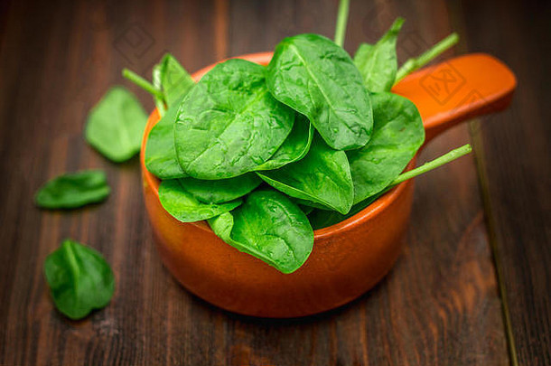 新鲜多汁的菠菜叶放在棕色的木制桌子上。天然产品，绿色，健康食品，维生素。