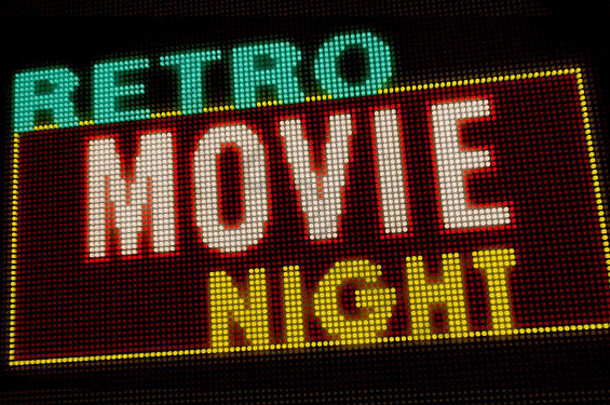 复古电影之夜介绍在大像素霓虹灯显示屏上照亮字母。灯泡显示屏上的明亮灯光文本。娱乐活动广告