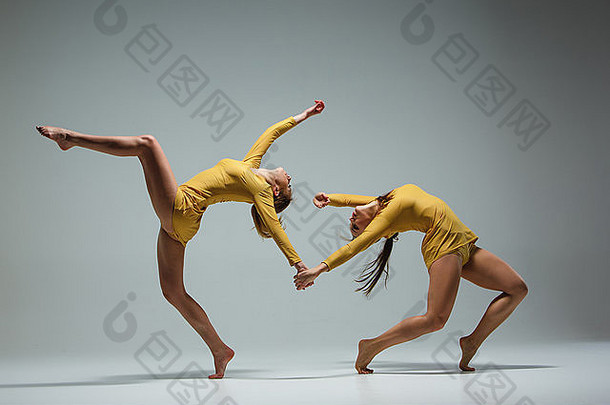 两位现代芭蕾舞演员在灰色背景下跳舞