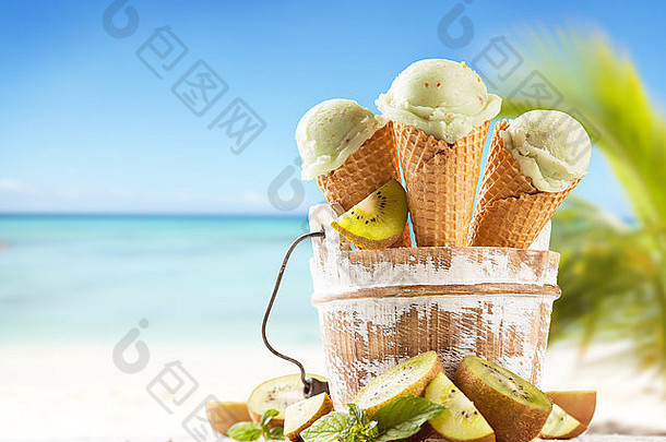 新鲜水果冰淇淋舀成锥形，模糊海滩背景