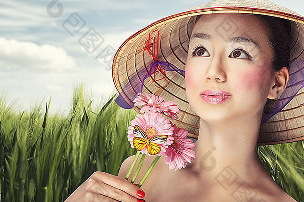 戴着传统帽子的美丽越南女孩手持鲜花