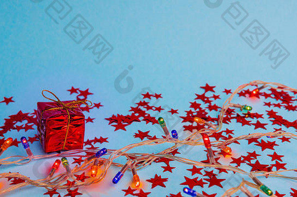 红色礼品盒，金色丝带，霓虹灯背景，特写。悬浮和空间。概念销售、折扣价格、圣诞节和新年