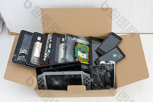 立陶宛维尔纽斯—2015年6月1日：纸箱中装有被拒收的破损三星品牌手机和平板电脑。设备准备好了