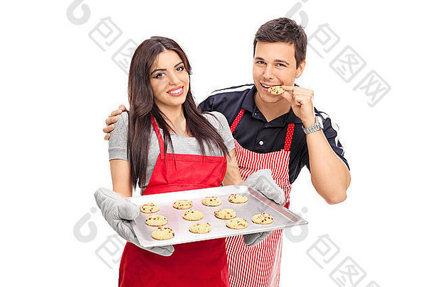 一名男子正在品尝他女朋友在白色背景下烤的饼干