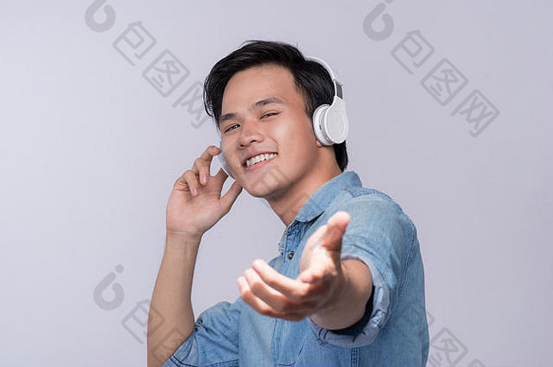聪明随意的亚洲男人，带着录音室背景的耳机