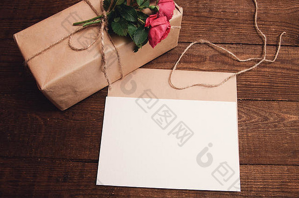 用牛皮纸包装的礼物，信封附近顶部有玫瑰花