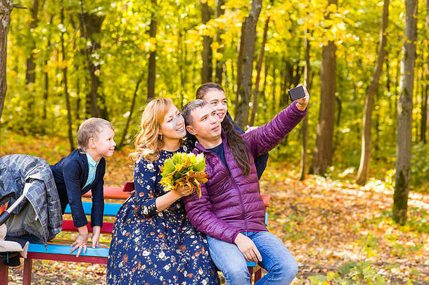 家庭、童年、季节、科技和人的概念——秋天公园快乐家庭摄影