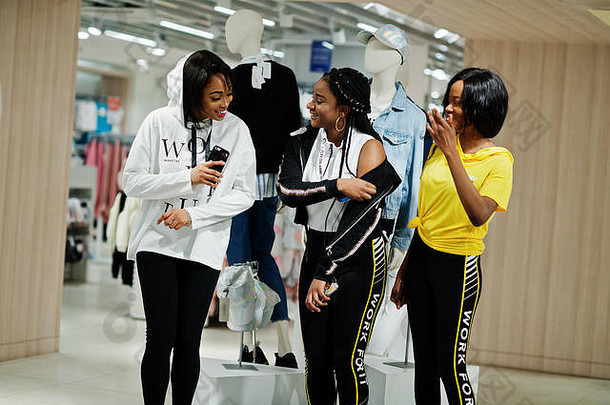 三名穿着运动服的<strong>美</strong>国黑人妇女在运动服装<strong>商场</strong>与人体模特比赛。运动商店<strong>主题</strong>。