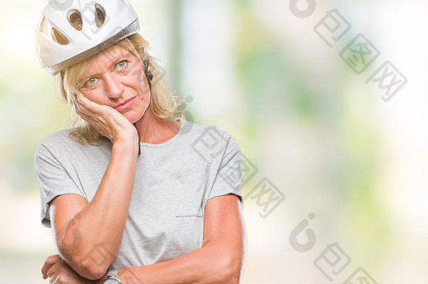 中年白人骑自行车的妇女，戴着安全帽，在孤立的背景下思考，看起来很累，对交叉路口的抑郁问题感到厌倦