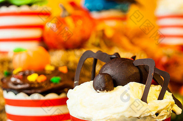 万圣节美食杯形蛋糕，节日装饰橙色背景。