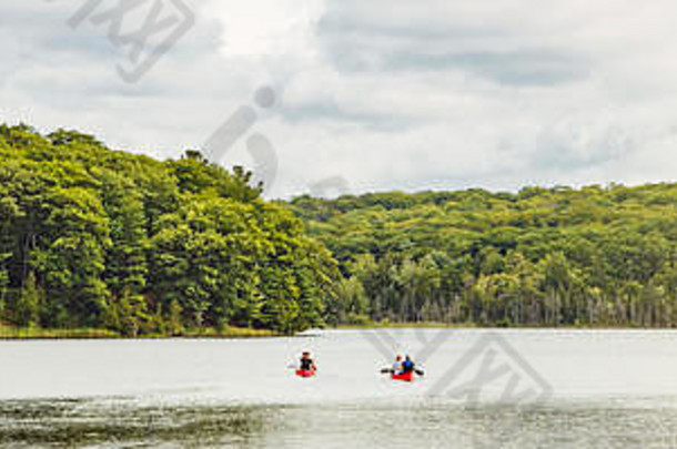 加拿大森林公园自然与家人朋友乘坐红色皮艇独木舟在水中。加拿大湖河地区的美丽风景。网络b
