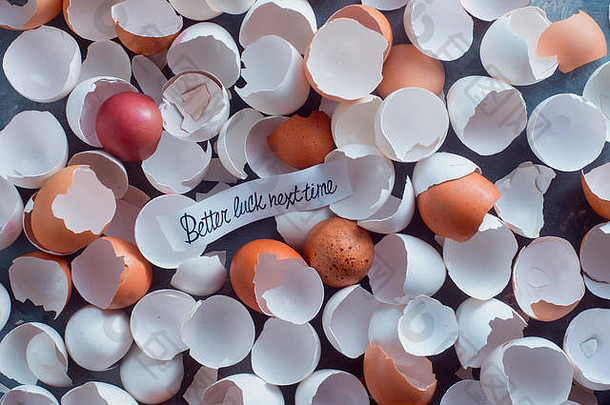 烘烤后留下的白色和棕色鸡蛋的破蛋壳上写着“祝你下次好运”。彩票中奖还是中奖