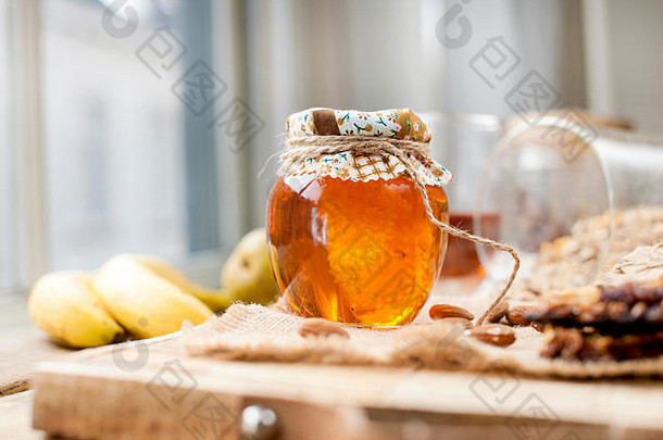 茶，坚果，蜂蜜，放在罐子里，香蕉放在靠近眼睛的木桌上。健康早餐。复古照片。