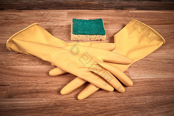 清洁手套和海绵放在棕色木制油浸橡木桌上