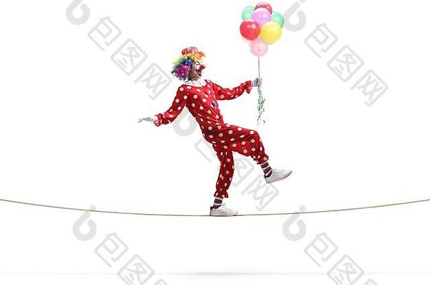完整的长度配置文件拍摄小丑走绳子持有群气球孤立的白色背景