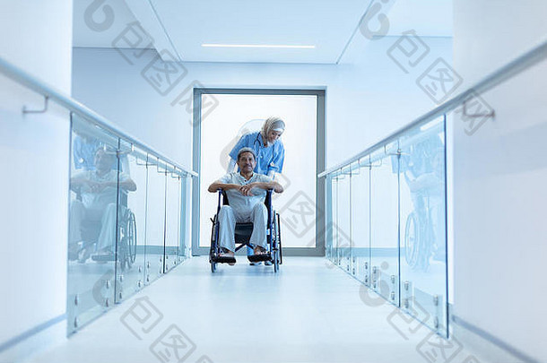 女医生在走廊推轮椅上的男病人