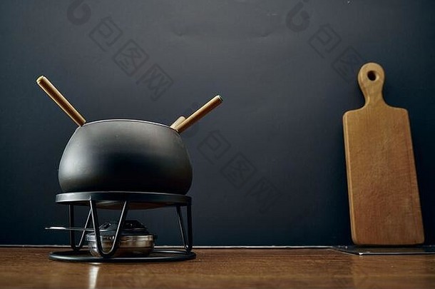 厨房场景用于烹饪<strong>火锅</strong>的黑色平底锅位于黑色背景的木桌上