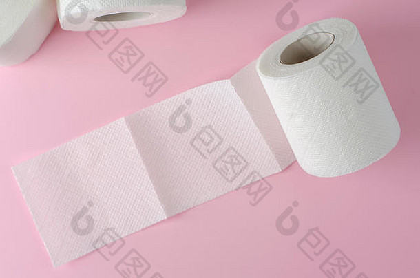 单面白色卫生纸卷，淡粉色背景。文本的空间。日常用品。卫生用品
