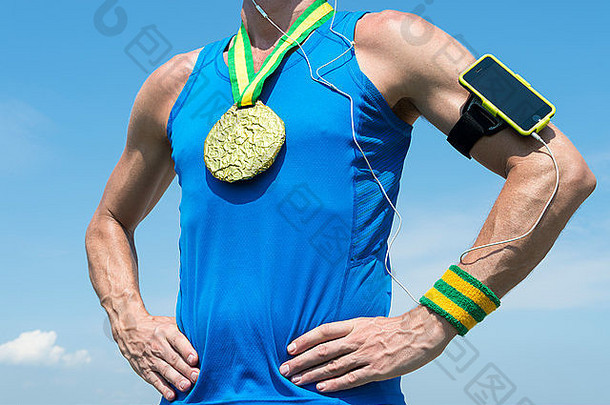 金牌运动员戴着手机臂章和耳机站在蓝天下