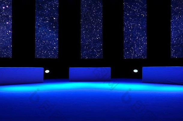 空荡荡的舞台上有三个座位和蓝色灯光