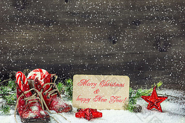 古董圣诞节装饰红色的星星古董婴儿鞋子雪木背景