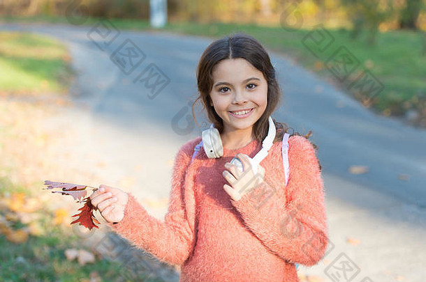 音乐秋天叶子快乐女孩穿耳机秋天景观可爱的孩子微笑耳朵立体声耳机小孩子现代耳机耳机技术