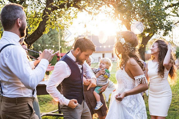 新娘和新郎在后院外的婚宴上跳舞。