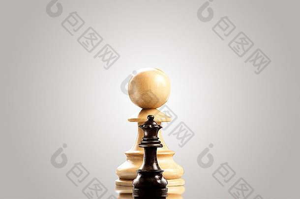 领导和勇敢观念；巨大的白色木制棋子，与一个黑色的小皇后对峙。