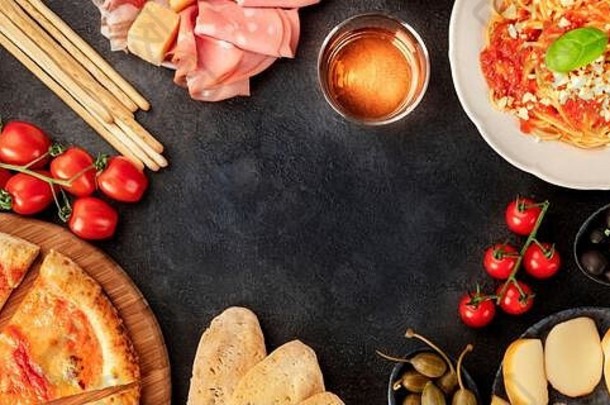 意大利<strong>美食</strong>全景与空间。比萨饼、意大利面、奶酪、火腿、葡萄酒、橄榄、香蒜酱、马槟榔，从上方拍摄，形成一个框架，并有一个文本位置