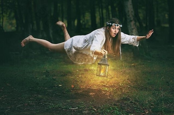 一位表情震惊的年轻女子<strong>发现自己</strong>正在树林中飞翔。幻想与超现实